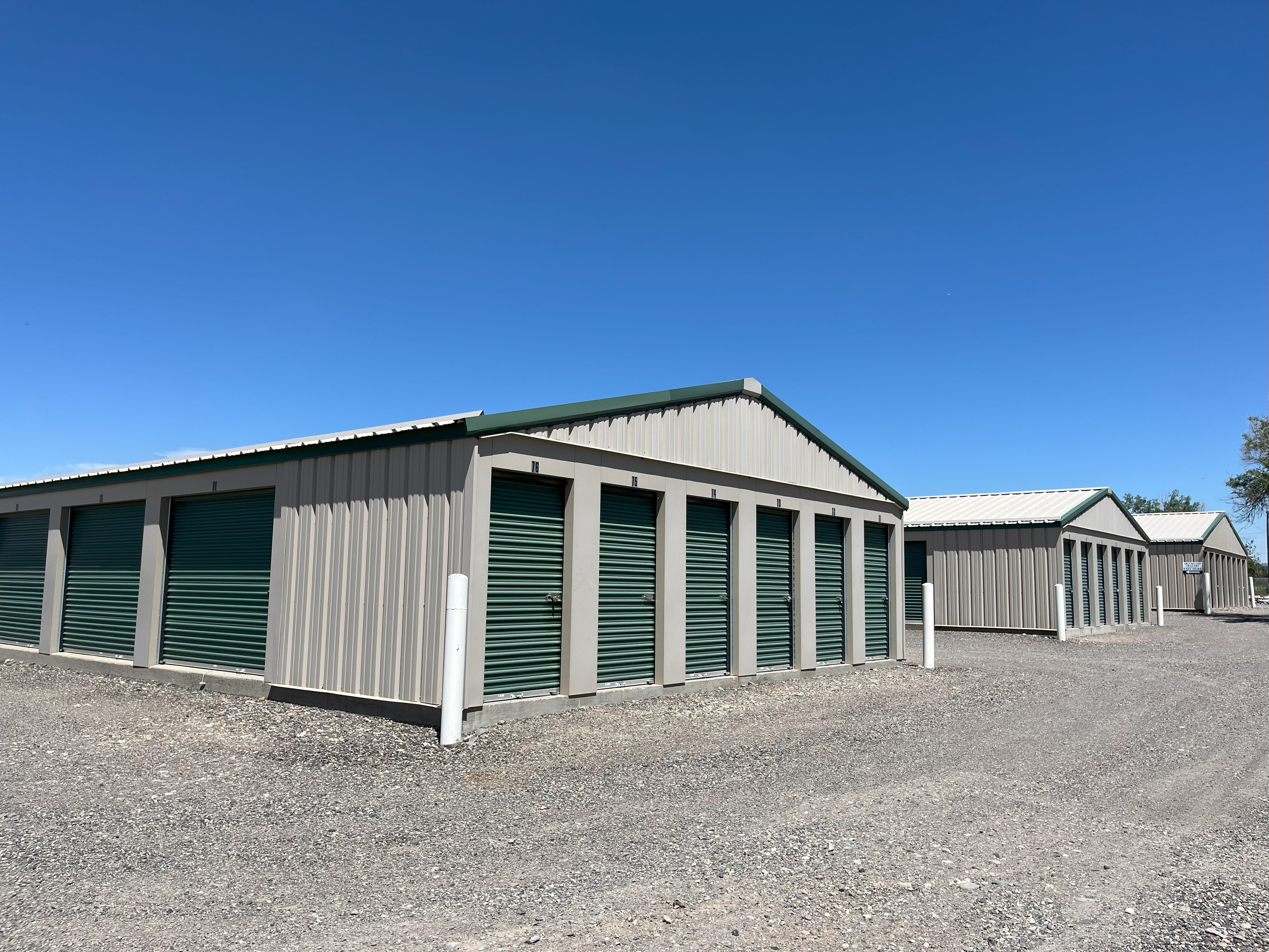 Green rollup doors tan storage building